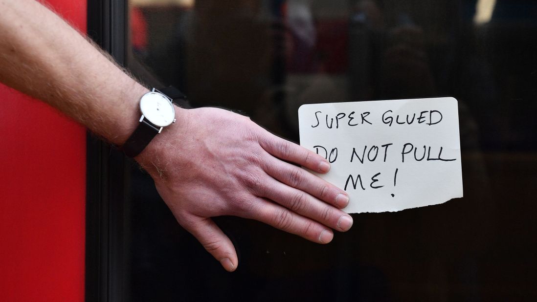 A climate change protestor who glued his hand to a window halts a train at Canary wharf station on the third day of environmental protests by the Extinction Rebellion group.