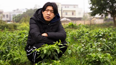 Wu Nengji poses on the rural pig farm from where he streams mini movies across China.  