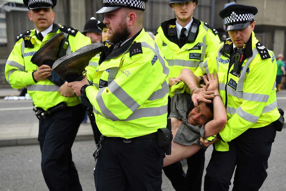 Police officers remove a protester from the Waterloo Bridge blockade during a coordinated protest on Tuesday, April 16.