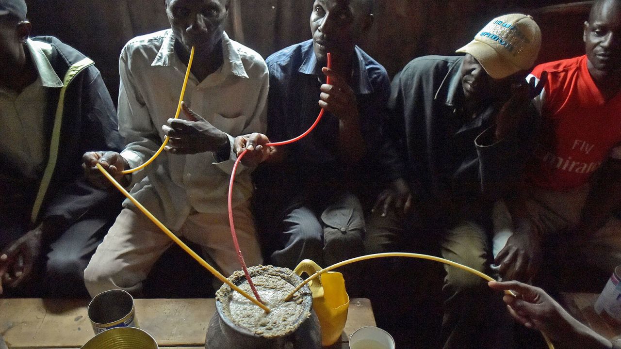 <strong>Busaa:</strong> Men in Kibera, Nairobi, gather around a pot to drink busaa, an alcoholic drink made from sorghum, maize or millet-flour. 