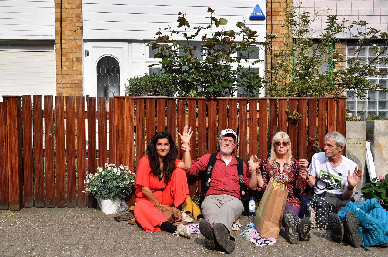 Activists, including Labour Party councilor Skeena Rathor, left, are photographed with their hands glued together and locked to a fence outside the home of Labour Party leader Jeremy Corbyn in north London on April 17.