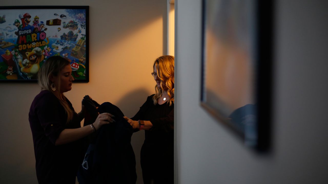 Jennifer Alba, right, grabs one of son Joseph's old sweatshirts for his girlfriend Kristin Rowell.