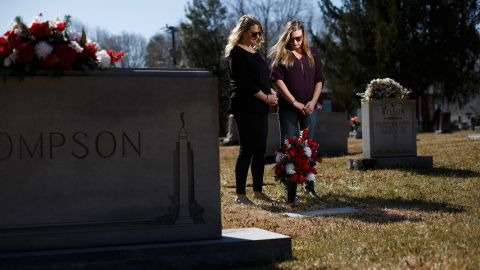 Jennifer Alba, left, and Kristin Rowell stand over Joseph Hockett's grave at the Shallow Ford Christian Church in Elon, North Carolina.