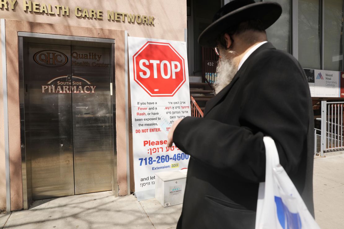 Signs warn of the dangers of a persistent measles outbreak in Williamsburg.