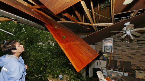 Sonya Banes surveys damage caused by a large oak tree that crashed through the ceiling of her mother's house Thursday in Learned, Mississippi. 