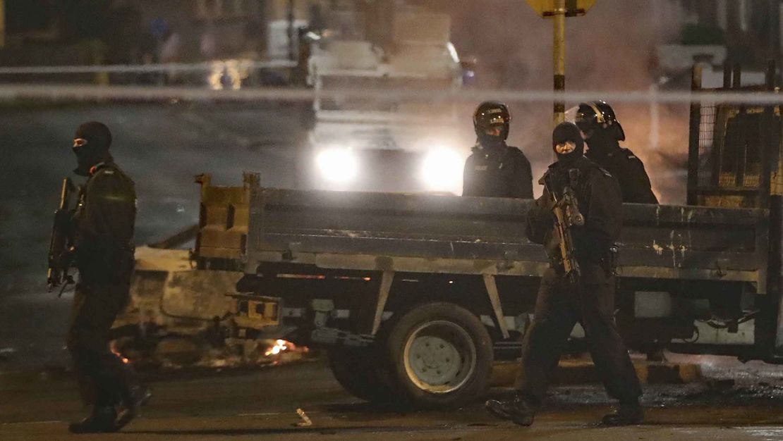 Police patrol the scene during Thursday night's violence. 