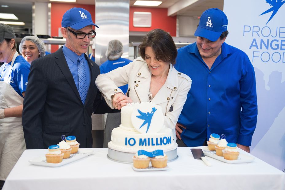 Williamson cuts a cake to commemorate Project Angel Food's 10-millionth meal in 2016.