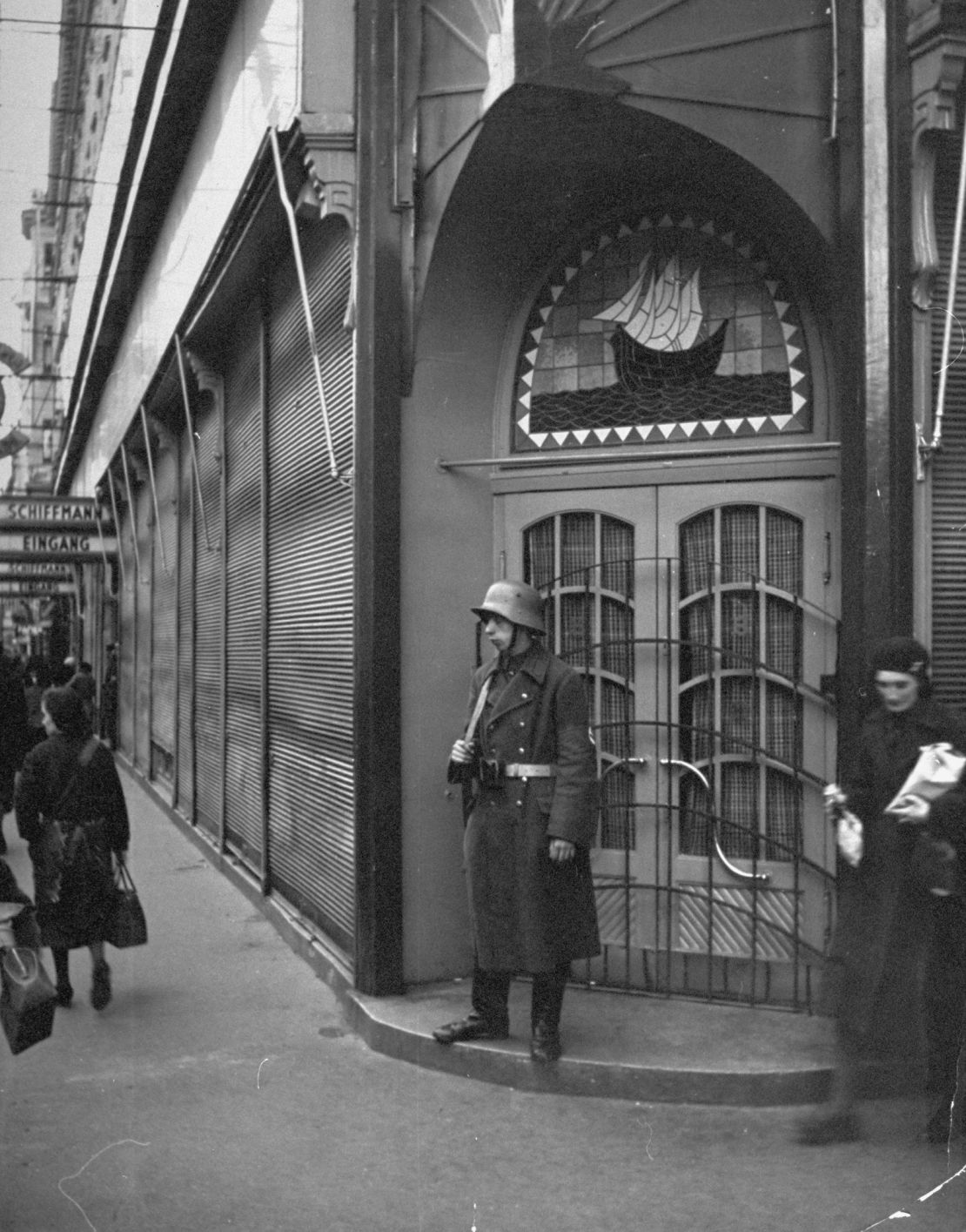 A guard stands outside Schiffmann's department store, a Jewish business, after it was taken over by the Nazis.