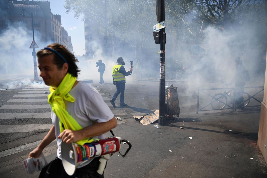 Protesters take cover from tear gas during an anti-government demonstration in Paris. 