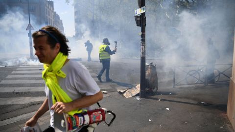 Protesters take cover from tear gas during an anti-government demonstration in Paris.