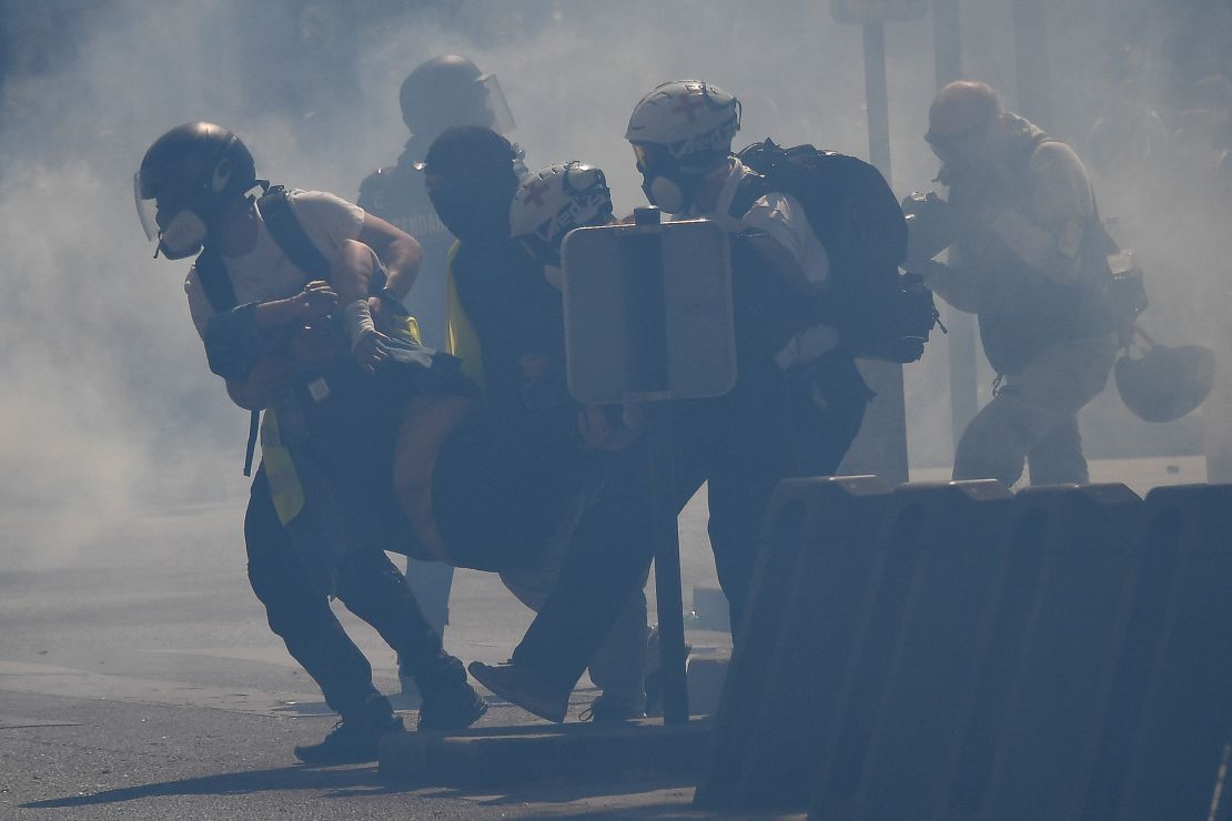 So-called "street medics" carry an injured protester amid tear gas.