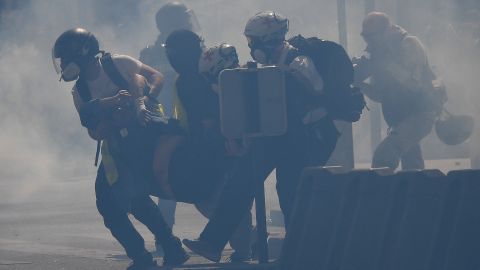 So-called "street medics" carry an injured protester amid tear gas.