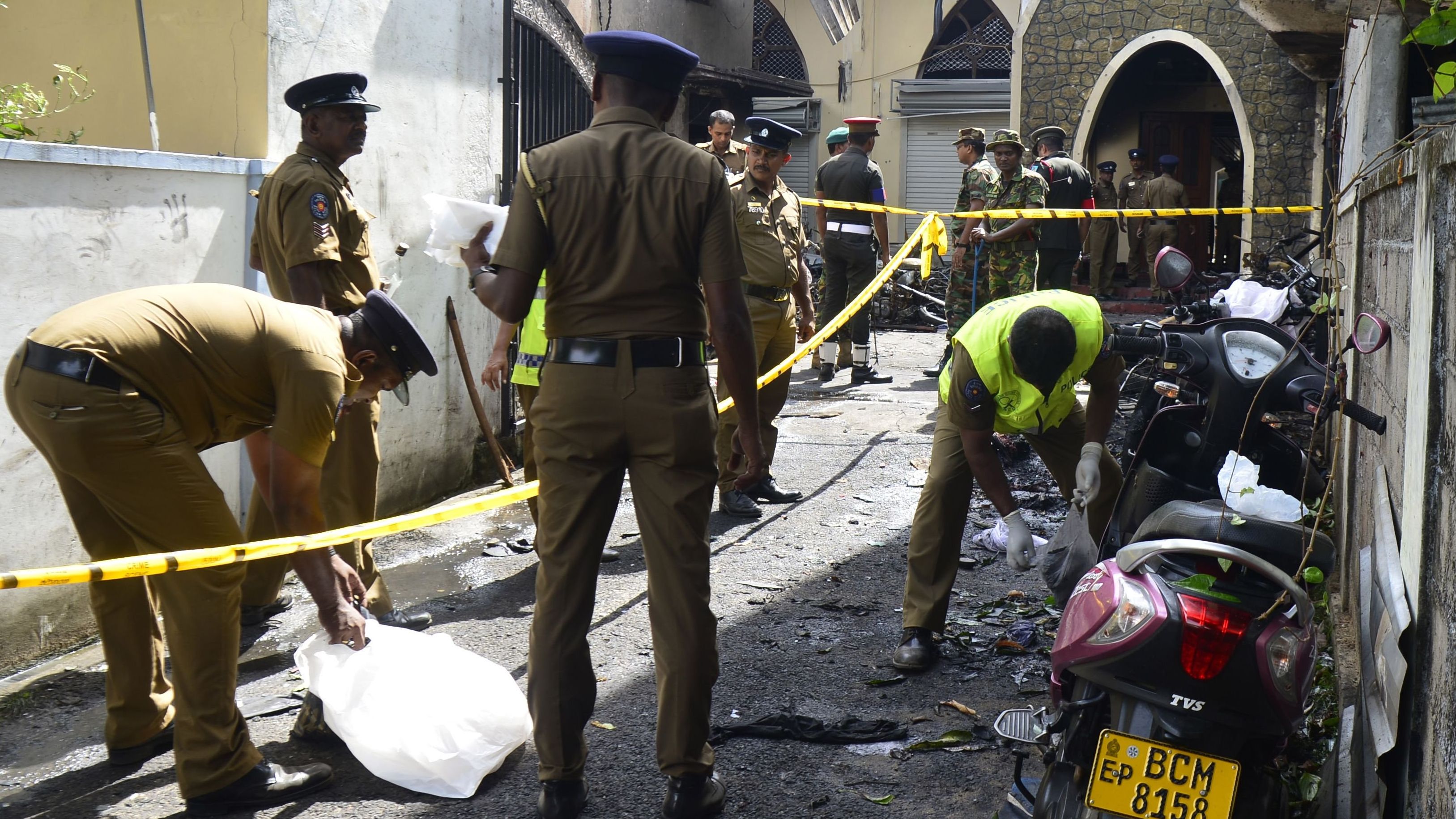 Security personnel and investigators sift through debris outside Zion Church in Batticaloa.