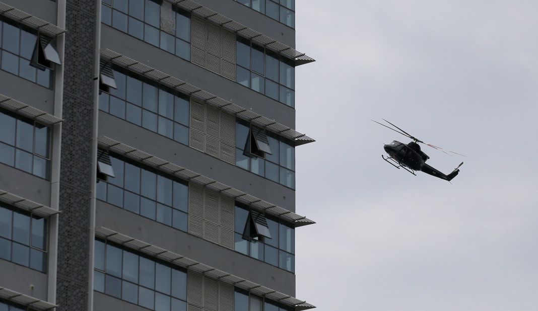 A Sri Lankan Air Force helicopter flies over a  house suspected to be a hideout of militants following a shootout in Colombo.