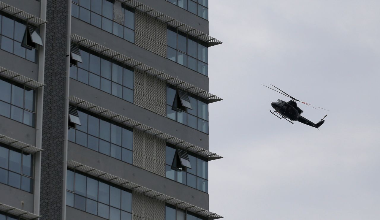 A Sri Lankan Air Force helicopter flies over a house suspected to be a hideout of militants following a shootout in Colombo.