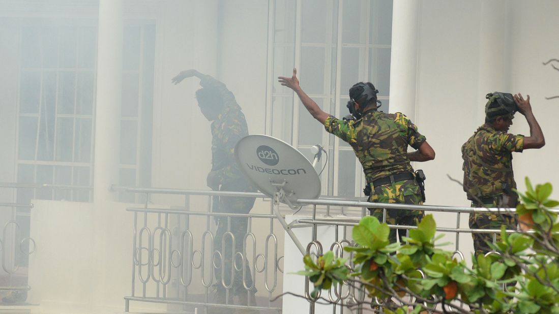 Sri Lankan Special Task Force personnel gesture outside a house during a raid following an explosion at a property in the Orugodawatta district of Colombo.