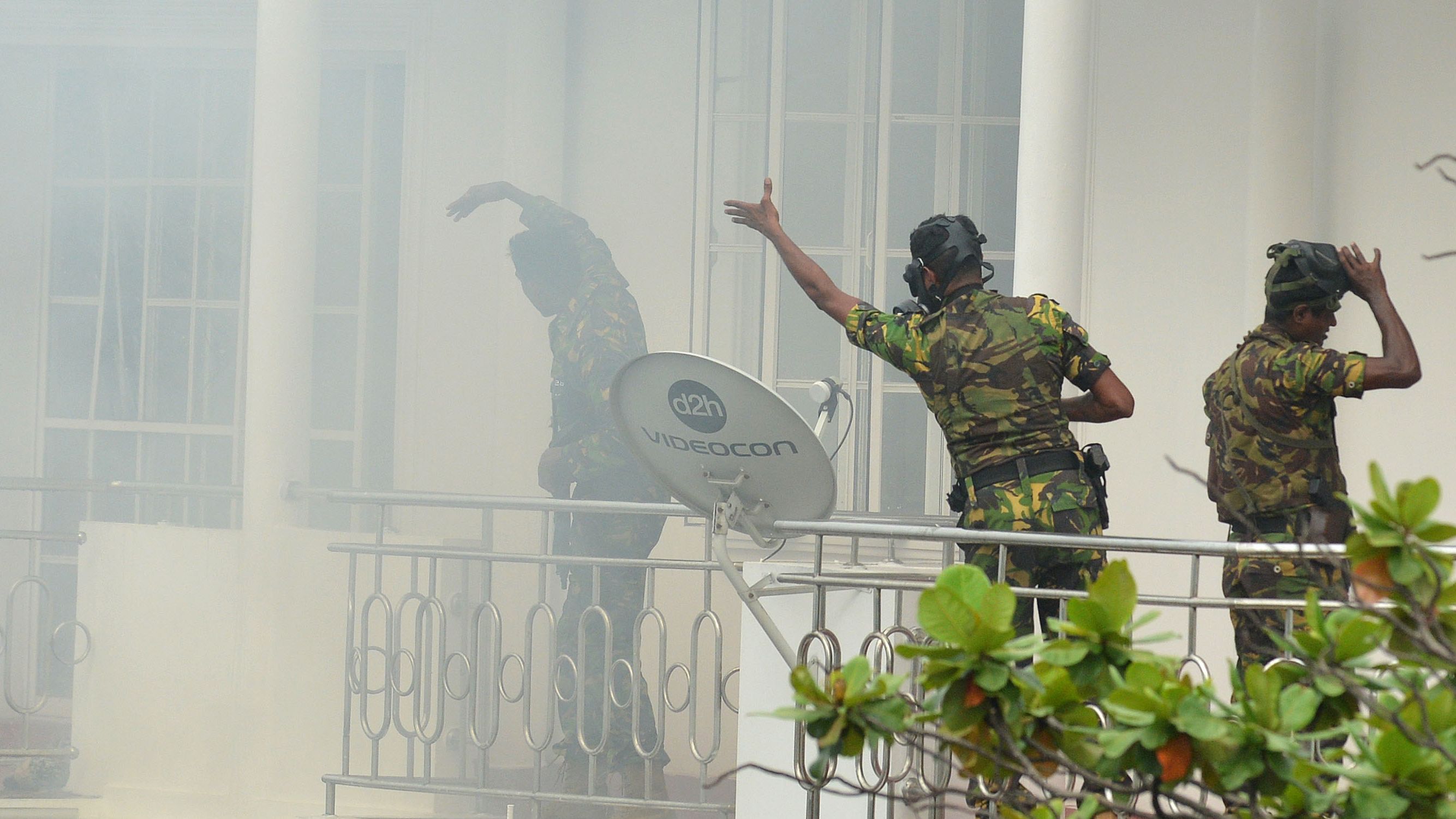Sri Lankan Special Task Force personnel gesture outside a house during a raid following an explosion at a property in the Orugodawatta district of Colombo.