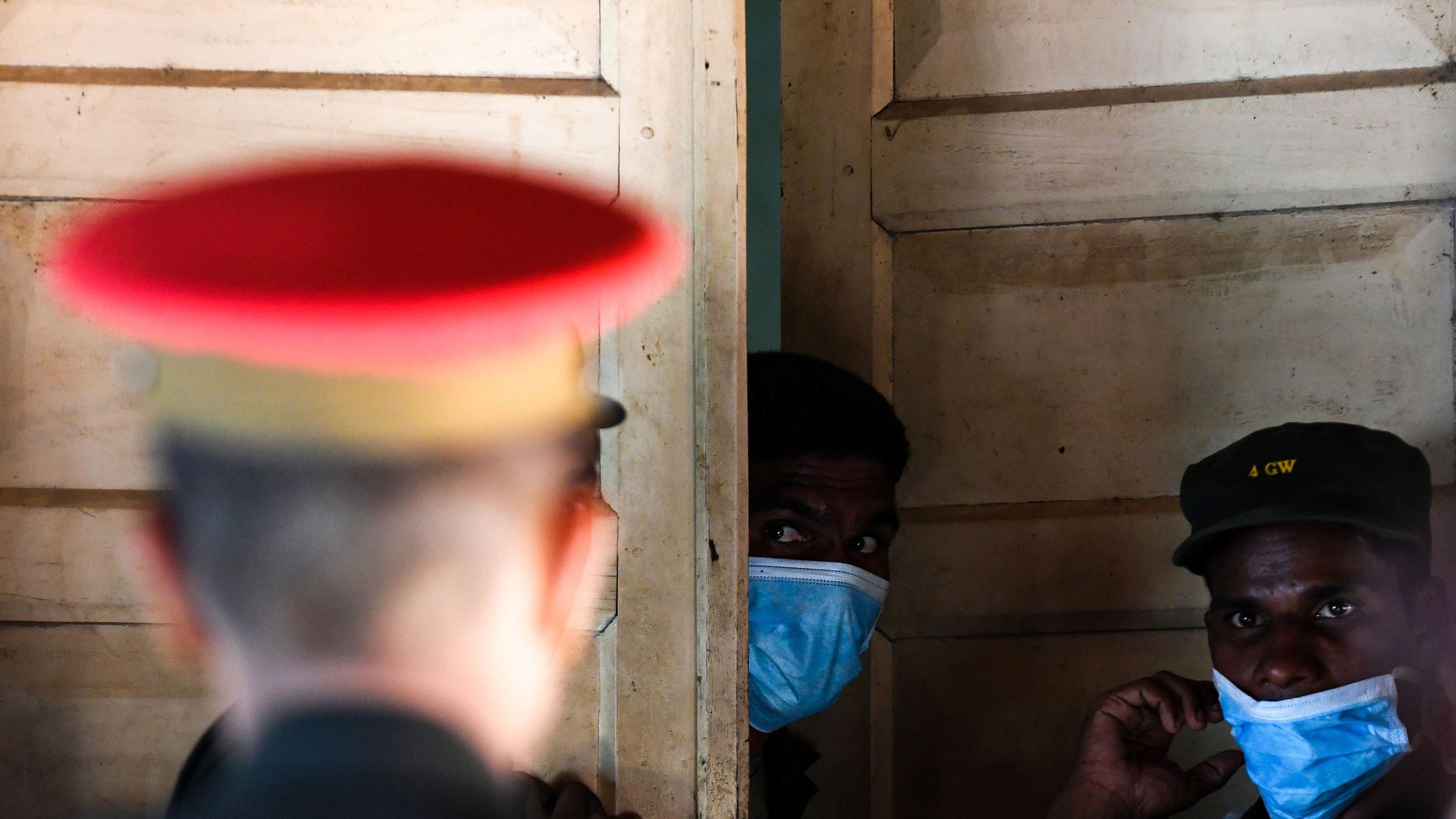Sri Lankan hospital workers and soldiers stand at the door to a morgue following a blast in a church in Batticaloa.