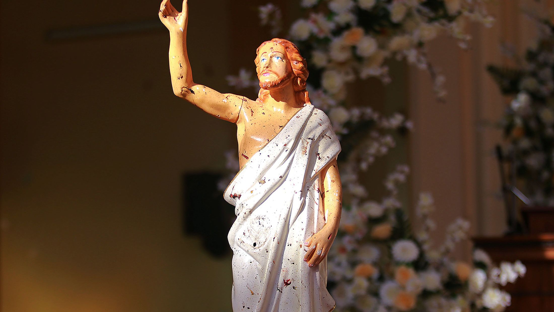 Blood stains are seen on a statue of Jesus Christ after a bomb blast inside a church in Negombo, on Sunday.
