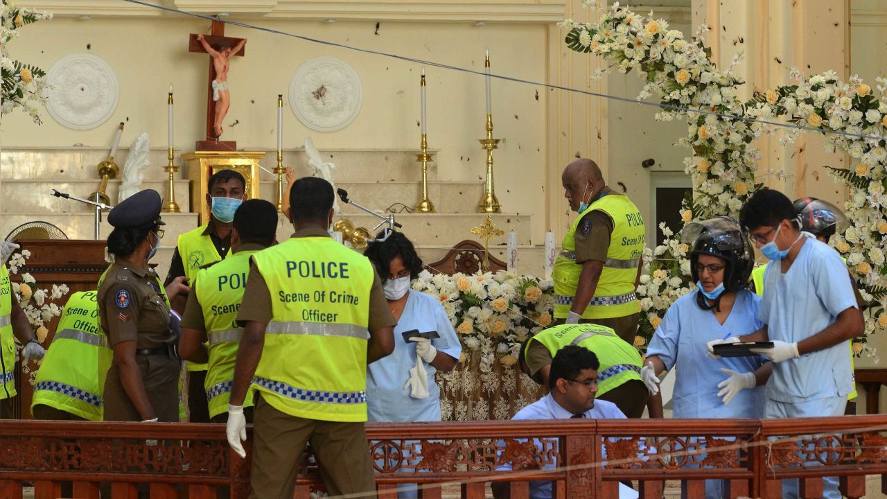 Police and forensics officials inspect the interior of St. Sebastian's Church in Negombo on Monday.