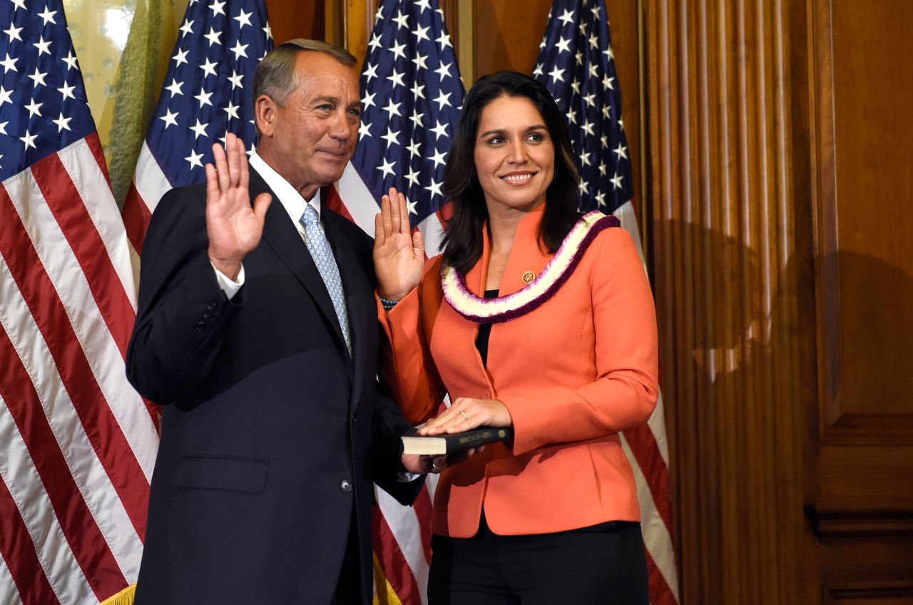 After winning re-election in 2014, Gabbard re-enacts her swearing-in with House Speaker John Boehner.
