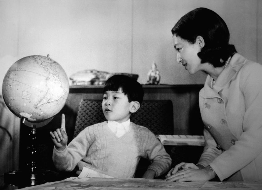 Naruhito studies a globe with his mother in February 1968.