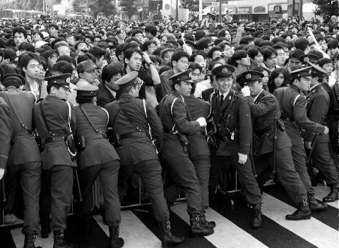 Tokyo metro police control an excited crowd of "Masako admirers" before the start of a parade honoring Naruhito and his new wife in 1993.