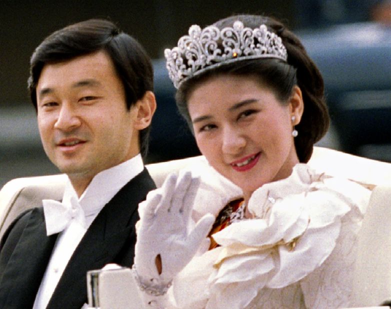 Crown Princess Masako waves to the imperial household staff as she and Naruhito depart for their wedding parade.