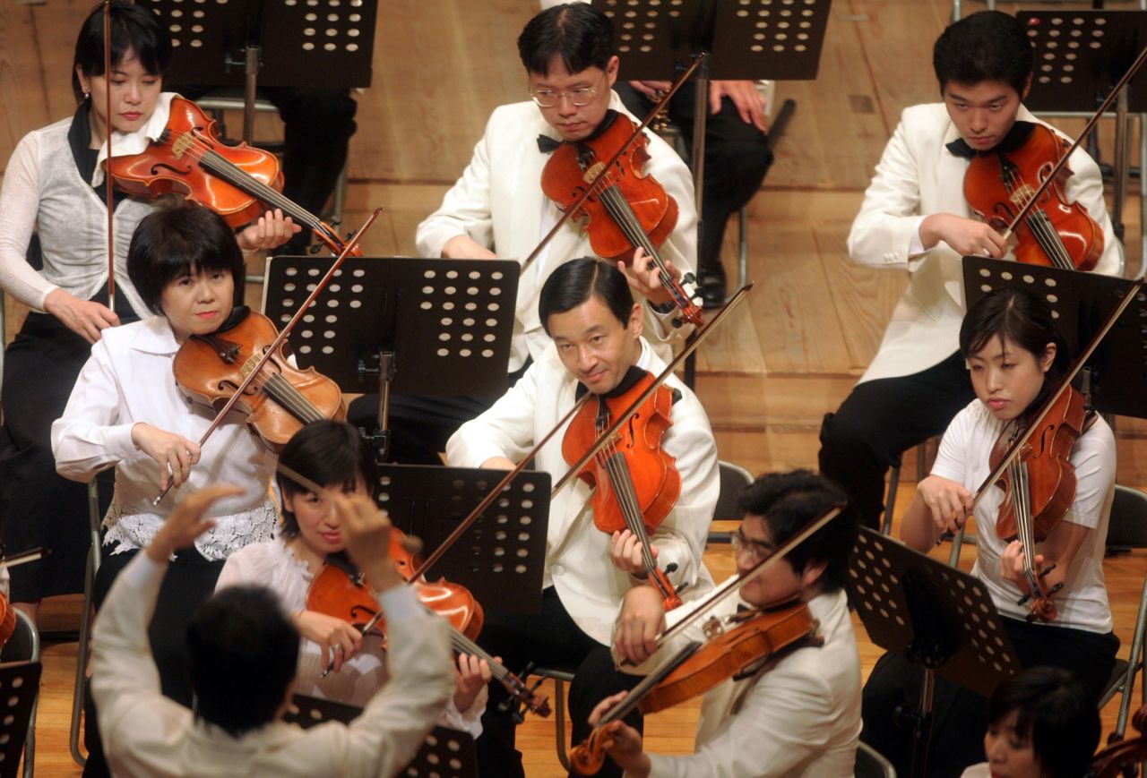 Naruhito, center, takes part in Gakushuin University's alumni orchestra concert in July 2004.