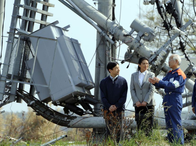 Naruhito and Masako listen to Iwanuma Mayor Tsneaki Iguchi while touring the tsunami-devastated city in June 2011.