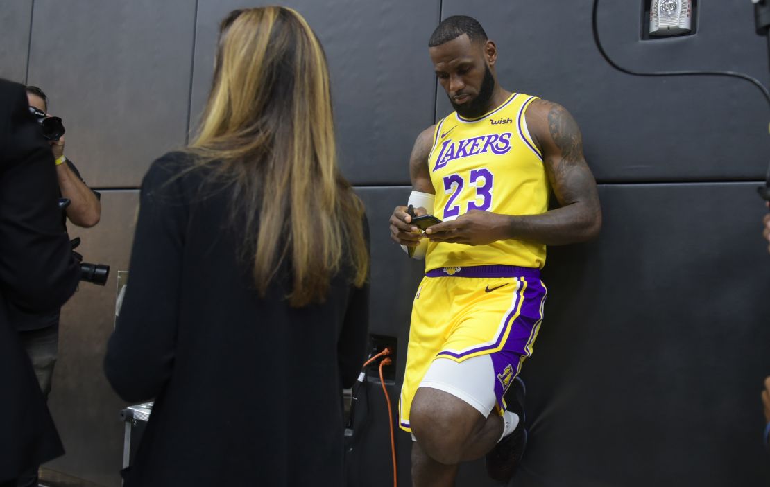 LA Lakers' LeBron James checks his cellphone ahead of a press conference