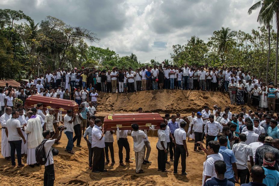 Coffins are carried to a grave during the mass funeral at St. Sebastian Church on April 23.