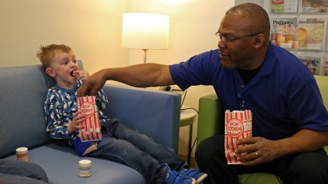 Gregory Watson jokingly steals some popcorn from Cooper.