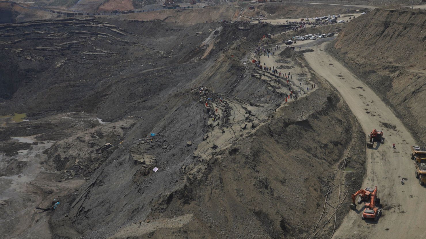 Search and rescue personnel look for miners at a jade mine following a landslide.