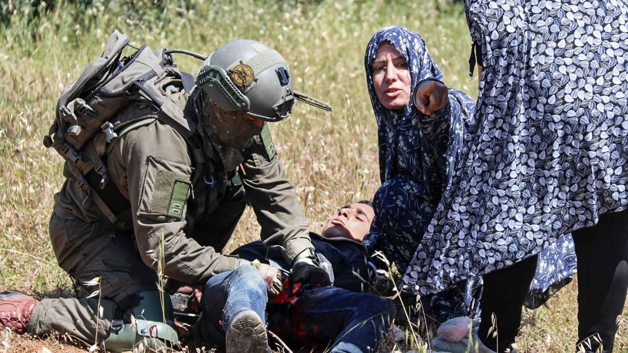 An Israeli soldier performs first aid on al-Badan.