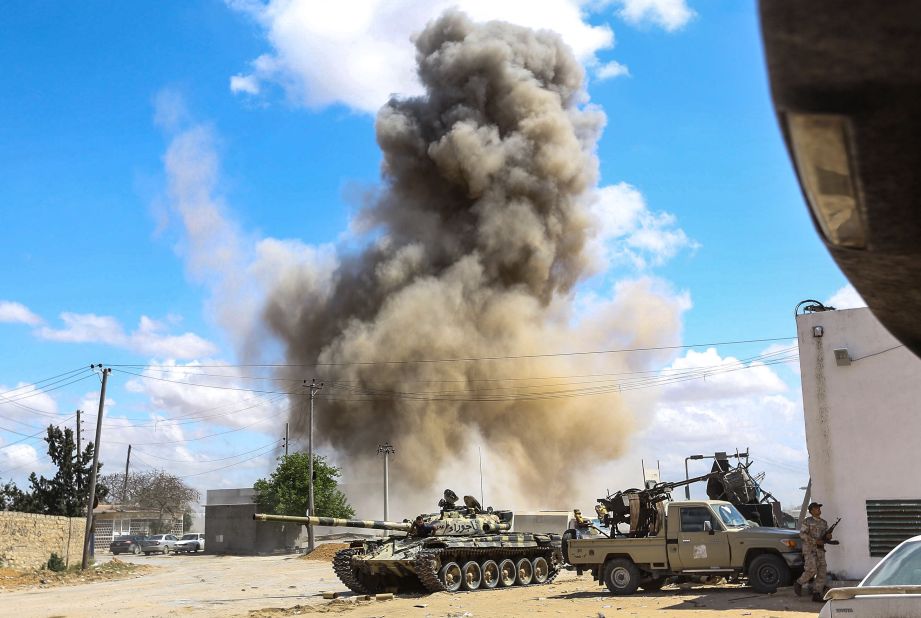 Smoke rises from an airstrike behind a tank and improvised fighting truck belonging to forces loyal to Libya's Government of National Accord, during clashes in Wadi Rabie, south of Tripoli, on April 12.