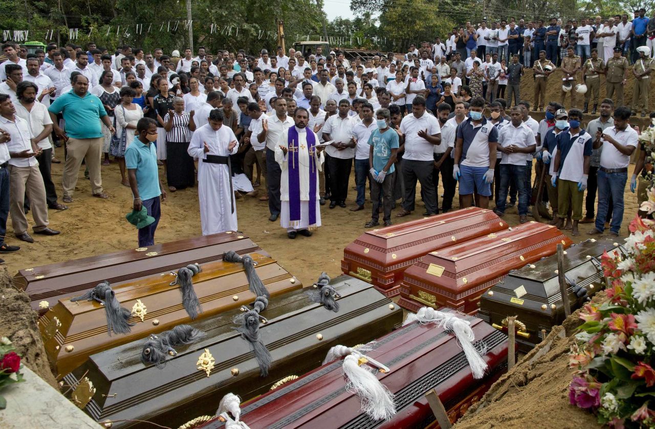 A priest conducts a burial ceremony for victims of the Easter Sunday bombings in Negombo, Sri Lanka, on Wednesday, April 24.