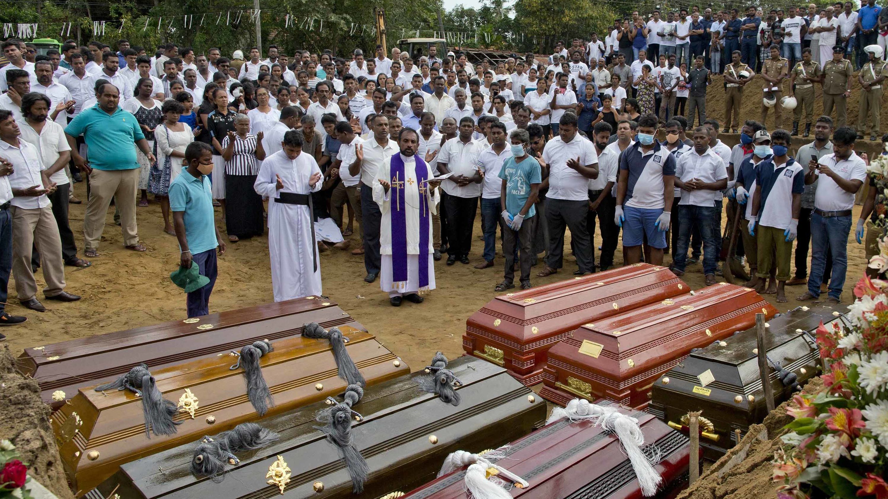 A priest conducts a burial ceremony for victims of the Easter Sunday bombings in Negombo, Sri Lanka, on Wednesday, April 24.