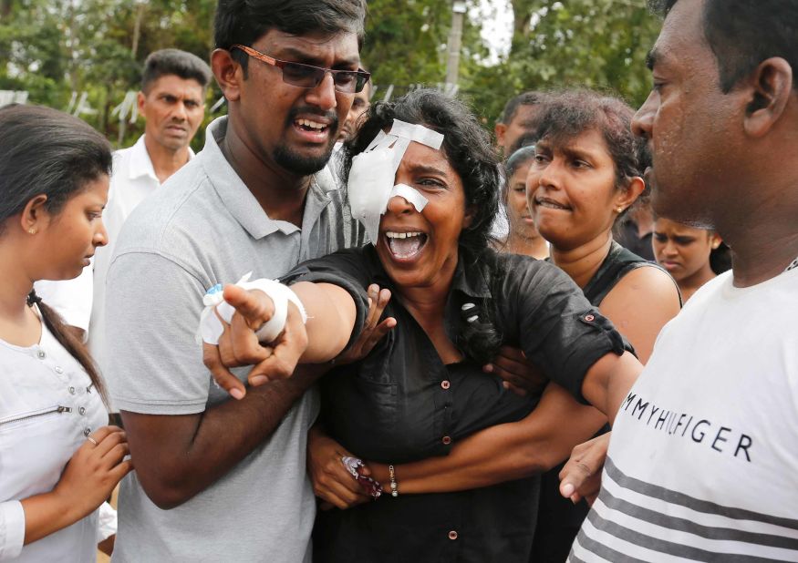 A woman who lost her husband and two children during the bombing at St. Sebastian's Church in Negombo yells toward the grave site during a mass burial on Wednesday.
