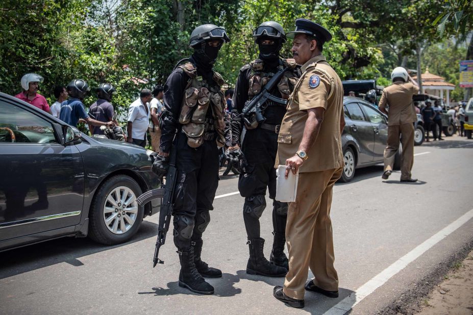 Military personnel talk with a police officer near the site where a package, believed to be a bomb, was detonated in a controlled explosion after being discovered in a nearby restaurant in Negombo on Wednesday, April 24.