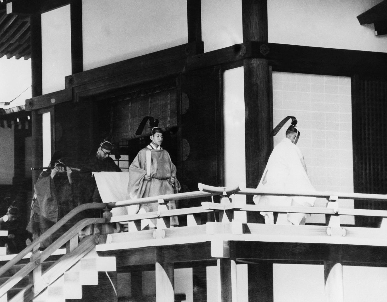 Akihito, second from the right, is assisted by an official as he enters a Shinto sanctuary inside the Imperial Palace on his wedding day in 1959.