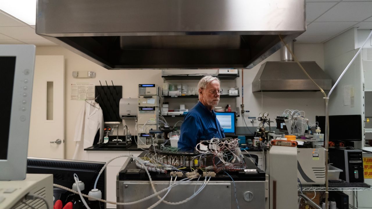 Davis in the Stanford Genome Technology Center, where his son's blood samples churn in sequencing machines.