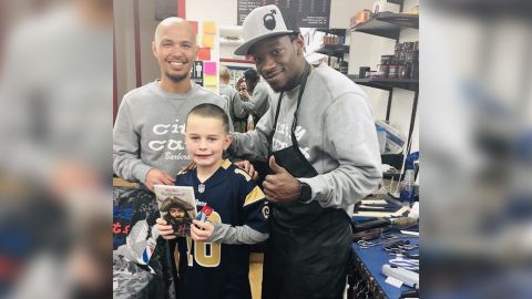City Cuts owner Jon Escueta and barber Jerry Jones pose with 8-year-old Connor after a haircut. 