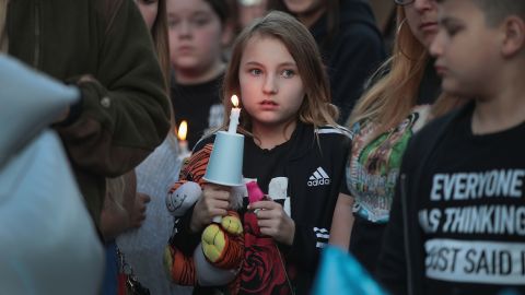 Mourners gather at a vigil.