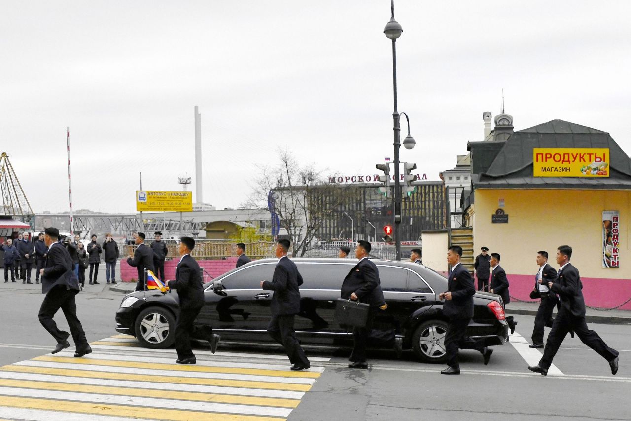 North Korean security staff members run with a car carrying leader Kim Jong Un at Vladivostok Station on Wednesday, April 24, in Vladivostok, Russia.  