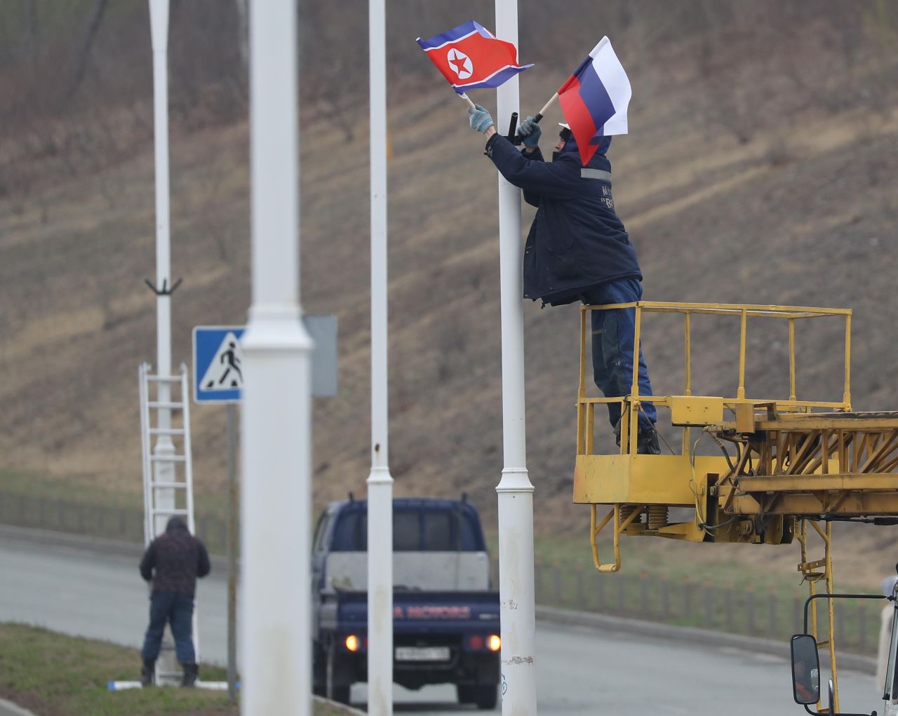Workers hang the North Korean and Russian flags on a road leading to the Far Eastern Federal University on Wednesday, April 24, in advance of the summit between North Korean leader Kim Jong Un and Russian President Putin. 