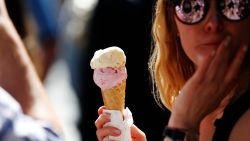 A woman eats an ice cream, during a sunny day in the Mont-Saint-Michel, northwestern France, on May 7, 2018. (Photo by CHARLY TRIBALLEAU / AFP)        (Photo credit should read CHARLY TRIBALLEAU/AFP/Getty Images)