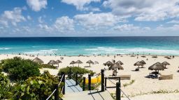 A general view from one of the accesses to the beach area with palapa umbrellas in Cancun, Quintana Roo State, Mexico, on February 16, 2019. - Playa del Carmen and Cancun are the top tourist destinations in Mexico, famous for their turquoise waters and white-sand Caribbean beaches. (Photo by Daniel SLIM / AFP)        (Photo credit should read DANIEL SLIM/AFP/Getty Images)