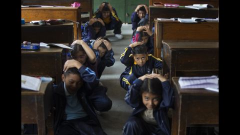 Schoolchildren crouch near their desks during an earthquake drill in Lalitpur, Nepal, on Thursday, April 25. Four years ago, <a href="https://www.cnn.com/specials/world/nepal-earthquake" target="_blank">thousands of people were killed</a> when an earthquake rocked Nepal.