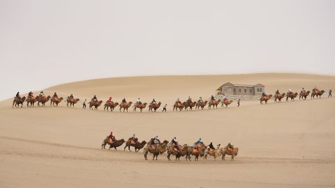 Tourists ride camels in Dunhuang, China, on Tuesday, April 23.